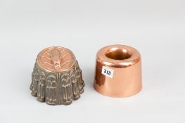A circular copper jelly mould and a tin and copper-topped jelly mould with corn on the cob