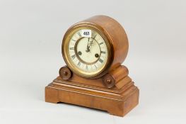 A walnut effect oblong based mantel clock, the drum set dial set on two scrolls and a stepped base