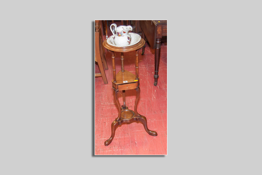 A small circular topped mahogany washstand with centre shelf and tiny drawer and a base shelf on