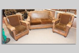 A three piece Art Deco rexine covered suite of two seater couch and a pair of armchairs on oak bun