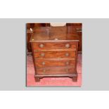 A compact late 19th Century mahogany four drawer chest with brass ring handles and bracket style