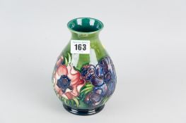 A Moorcroft pottery green ground vase of waisted form, tube line decorated in the anemone pattern,