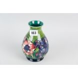 A Moorcroft pottery green ground vase of waisted form, tube line decorated in the anemone pattern,