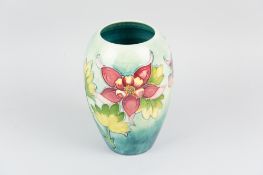 A Moorcroft pottery ovoid shaped vase with graduating blue green ground and tube line decoration