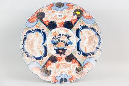 A late nineteenth century Japanese Imari charger with wavy rim, profusely decorated with outer