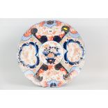 A late nineteenth century Japanese Imari charger with wavy rim, profusely decorated with outer