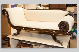 A 19th Century Empire style scroll ended chaise longue on swept supports with brass cup castors (