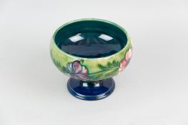 A Moorcroft pottery pedestal bowl decorated with a blue green ground and tube line band of flowers