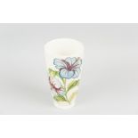 A Moorcroft pottery cream ground tapering vase, tube line decorated in hibiscus pattern with