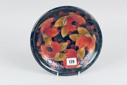 A Moorcroft blue ground plate with tube lined 'Pomegranate' pattern, 21.5cms diam, impressed marks