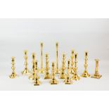 A pair of circular based brass candleholders with slim plain slightly tapered columns, 12.5 ins (