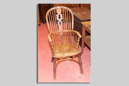 An elm splat and spindle elbow chair with turned front and rear supports and crinoline stretcher