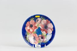 A Moorcroft pottery footed bowl, tube line decorated in the anemone pattern in a cobalt blue ground,
