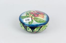 A Moorcroft pottery circular pot and cover, the lid decorated with a modern hibiscus pattern on a