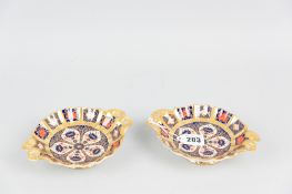 A pair of Royal Crown Derby Imari patterned circular dishes, each with twin pierced handles and to a