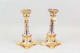 A pair of Royal Crown Derby old Imari candle holders, each on a square shaped base with shaped