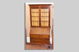 A circa 1900 mahogany bureau bookcase with shaped crown over twin glazed doors with bevelled edged