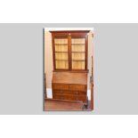 A circa 1900 mahogany bureau bookcase with shaped crown over twin glazed doors with bevelled edged