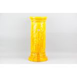 A Burmantofts yellow glazed jardiniere pedestal of cylindrical form with raised flowers  to a wide