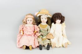 An antique bisque headed doll with composition body and jointed composition limbs, dressed in