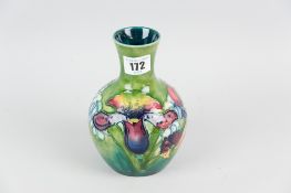 A Moorcroft pottery baluster shaped vase with waisted neck, a green ground vase having a tube line