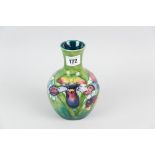 A Moorcroft pottery baluster shaped vase with waisted neck, a green ground vase having a tube line