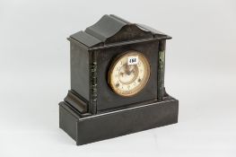 A black slate oblong based mantel clock with green mottled pillars either side of the circular