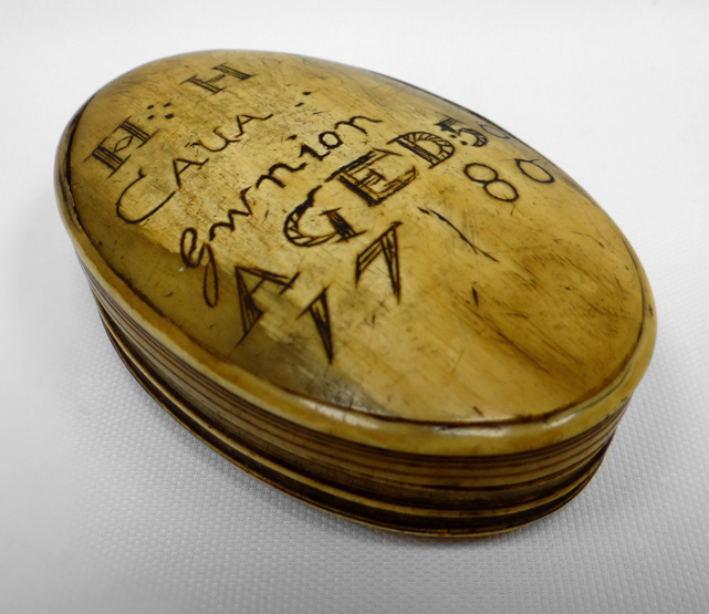 A horn lidded snuff-box of oval form with sgraffito writing to the lid as follows 'HH CAUA Gwnion