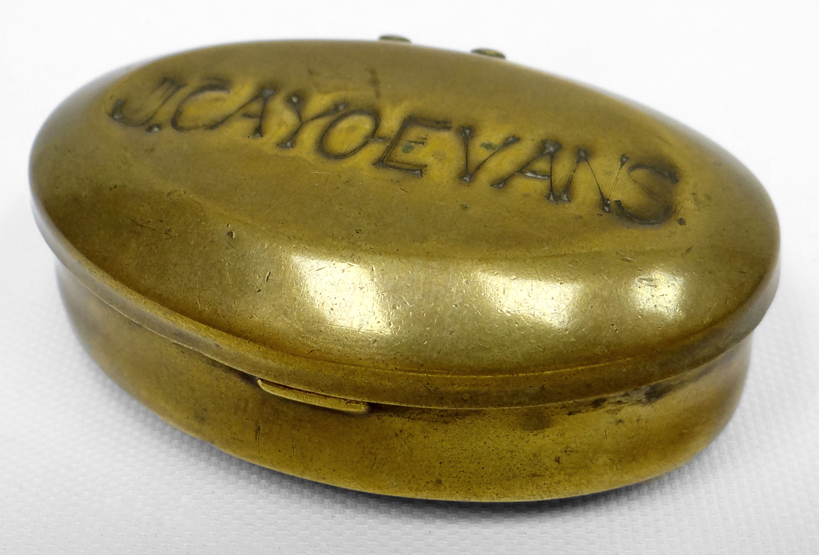 A brass oval snuff box with hinged lid impressed 'J CAYO EVANS', 2.75ins long (7cms), the name is