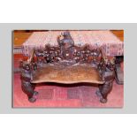 A German Black Forest carved bench with standing bear supports, leaf carved back and side supports