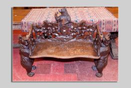 A German Black Forest carved bench with standing bear supports, leaf carved back and side supports
