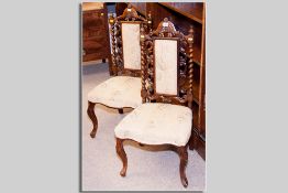 A pair of Victorian rosewood hall chairs having twist uprights with scrolled and upholstered backs