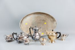 An oval galleried tray with a four piece electroplated tea service and a three piece electroplated