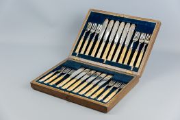 An oak canteen of twelve bone handled fish knives and forks with silver ferrules