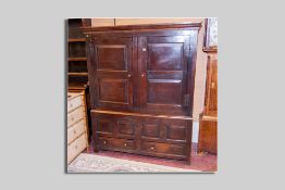 An 18th Century oak two piece press cupboard, the upper section with two fielded panelled doors with