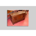 An antique oak dower chest having three square front fielded panels, fielded end panels and two base