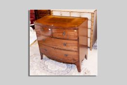A 19th Century bow front chest of two long and two short drawers with brass ring handles on