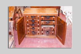 A 1920's mahogany and walnut filing cabinet, the twin doors revealing ten filing drawers all with