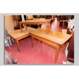 An oblong pine farmhouse table with drawer to one end, a similar table with two side drawers and a
