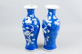 A pair of 19th Century blue and white prunus blossom decorated vases of waisted form with flared