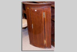 A late Georgian mahogany single door inlaid corner cupboard with brass 'H' hinges and brass