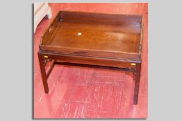 A mahogany butler's tray on a low table stand having corner chamfered supports and stretchers