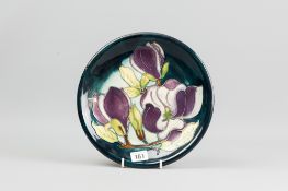 A Moorcroft pottery 'Magnolia' blue green ground plate, painted and impressed factory marks to the