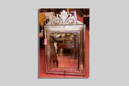 A large late Victorian bevelled wall mirror having wide floral canted mirror panels and with