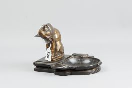 A bronzed spelter Art Deco dished tray flanked by stylized tulips with a gilt decorated seated cat