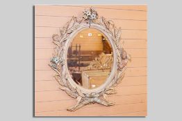 An oval painted pine bevelled wall mirror, the frame decorated all round with corn sheaves,