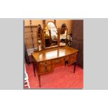 An Edwardian mahogany and inlaid kneehole dressing table having a centre drawer with two drawers