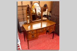An Edwardian mahogany and inlaid kneehole dressing table having a centre drawer with two drawers