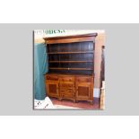 A 19th Century oak and mahogany Welsh dresser having a three shelf rack over a breakfront base