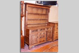 An Anglesey oak and mahogany dresser with three shelf rack above an arrangement of three frieze
